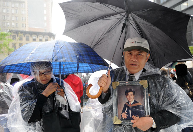 11일(현지시간) 미국 뉴욕의 그라운드 제로에서 911테러 발발 8주기 추모행사가 열린 가운데 한국인 강준구 씨가 아들의 사진을 들고 추모식에 참석하고 있다. 【뉴욕(미 뉴욕주)=신화/뉴시스】