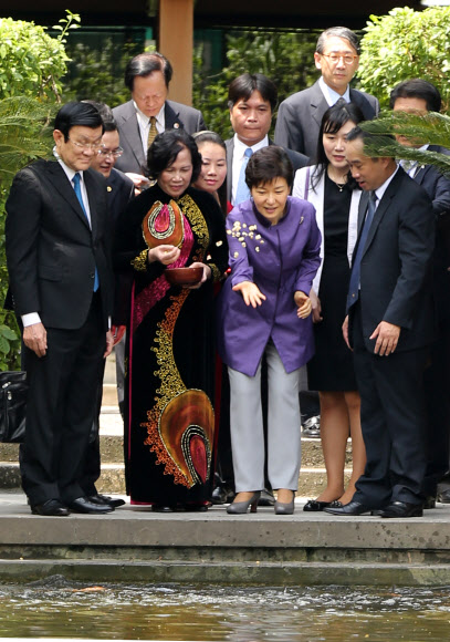 9일 오후 하노이 호찌민 거소에서 쯔엉 떤 상 국가주석과 잉어 떼에 먹이를 주는 모습.  청와대 제공