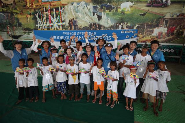 우리금융 직원들이 지난 5월 미얀마에서 자원봉사 활동을 한 뒤 현지 어린이들과 기념사진을 찍고 있다. 우리금융은 2010년부터 매년 글로벌 자원봉사단을 파견하고 있다. 우리금융 제공