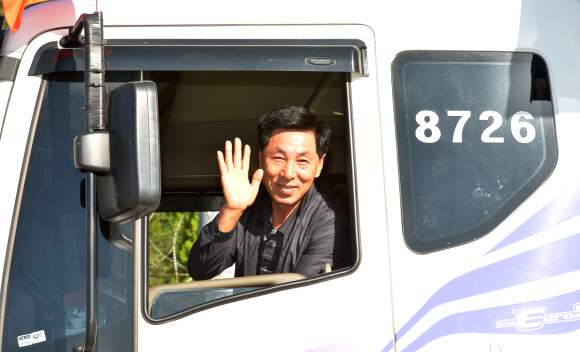 개성공단 사태 발생 이후 166일만에 재가동이 시작된 16일 경기도 파주 도라산남북출입사무소에서 개성공단 입주기업 차량 운전자가 북측으로 출경을 하며 취재진을 향해 손을 흔들고 있다.  손형준 boltagoo@seoul.co.kr