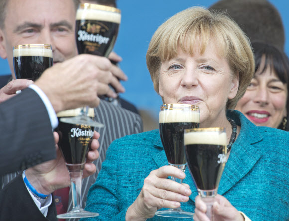 앙겔라 메르켈 독일 총리가 15일(현지시가) 튀링겐주 바트쾨스트리츠에서 열린 기독민주당(CDU) 유세에서 연설을 마친 뒤 당 관계자들과 흑맥주로 건배하고 있다. 바트쾨스트리츠 AP 연합뉴스
