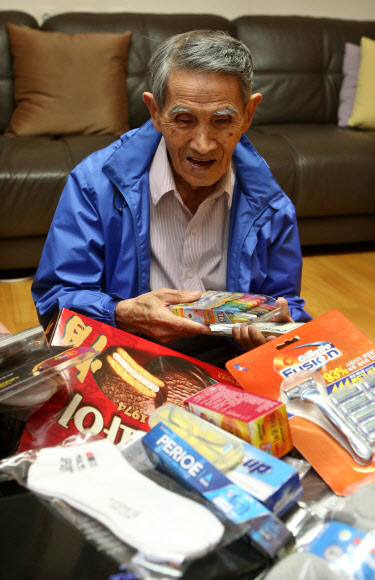 북한이 추석 이산가족 상봉행사 연기를 발표한 21일 오후 상봉 대상자인 강능환 할아버지가 서울 송파구 자택에서 취재진에게 북한에 있는 가족들에게 주려고 준비한 물건들을 보여주고 있다. 연합뉴스