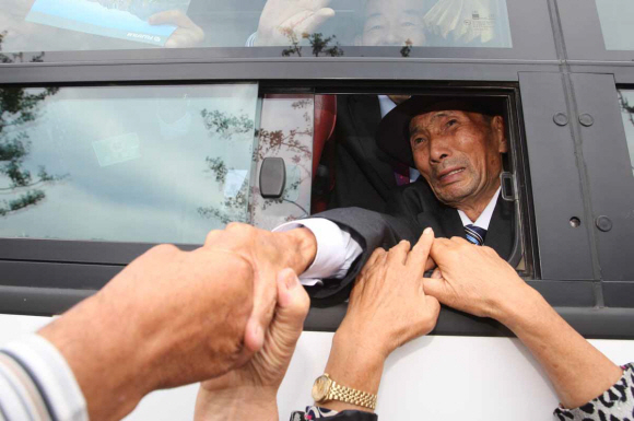 이산가족 2차 상봉행사 마지막날인 1일 금강산 면회소에서 남측 가족들이 버스를 타고 떠나는 북측 가족들의 손을 잡고 아쉬워하고 있다. 사진공동취재단