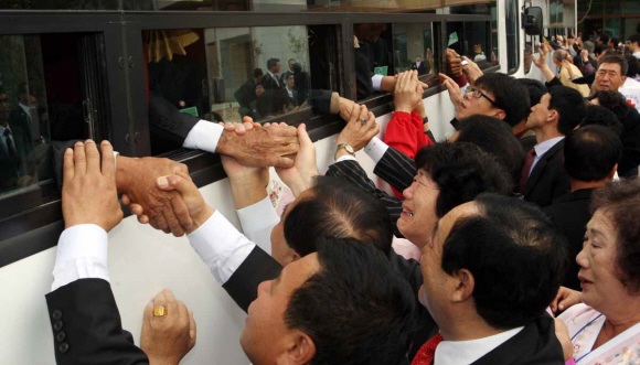 이산가족 2차 상봉행사 마지막날인 1일 금강산 면회소에서 남측 가족들이 버스를 타고 떠나는 북측 가족들의 손을 잡고 아쉬워하고 있다. 사진공동취재단