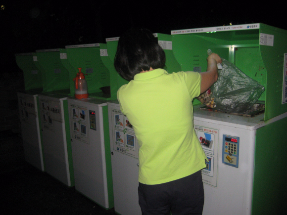 서울의 한 공공주택단지에서 주민이 무게 인식기(RFID)에 음식물쓰레기를 버리고 있다.