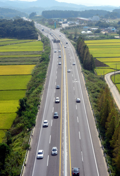 한가로운 고속도로 추석 연휴 마지막날인 22일 전남 장성군의 호남고속도로에서 귀경 차량들이 황금빛으로 물든 들녁 사이를 달리고 있다. 연합뉴스