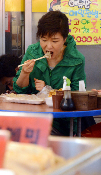 박근혜 대통령이 24일 인천 부평종합시장 내 한 모둠전 가게를 방문해 전을 맛보고 있다.  이언탁 utl@seoul.co.kr