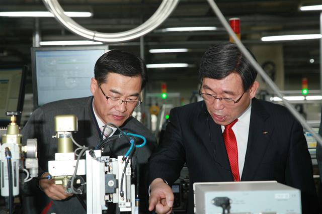 박철곤(오른쪽) 한국전기안전공사 사장이 직접 LS산전 공장을 방문해 0.1초의 순간정전도 허용하지 않기 위해 설비 점검을 지시하고 있다. 한국전기안전공사 제공
