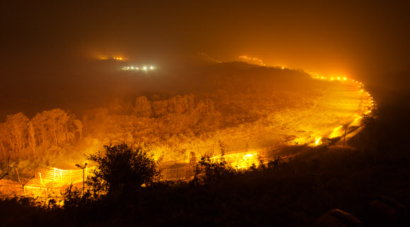 철원지역 비무장지대(DMZ)의 밤. 산이나 구릉이 거의 없는 지역을 철책과 경계등이 가르고 있다. 2013년 가을 강원도 철원군 중부전선.  연합뉴스