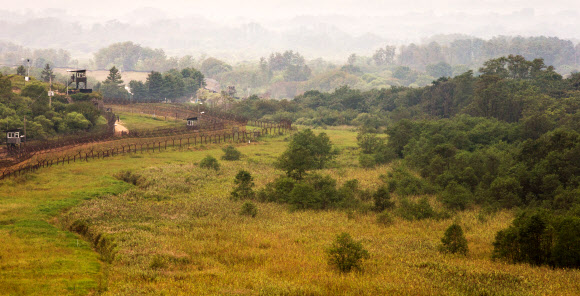 안개 낀 철원지역 비무장지대(DMZ). 산이나 구릉이 거의 없는 지역을 철책이 가르고 있다. 한국전쟁 당시 김일성이 전략적 요충지이자 곡창지대인 철원 평야를 빼앗기고 3일 동안 울었다는 이야기가 전해진다. 2013년 가을 강원도 철원군 중부전선. 연합뉴스