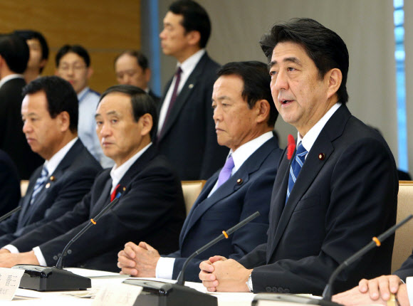 아베 신조(오른쪽) 일본 총리가 1일 도쿄 총리관저에서 열린 정부여당 정책간담회에서 현재 5%인 소비세율을 내년 4월부터 8%로 인상하겠다고 밝히고 있다.  도쿄 AP 연합뉴스