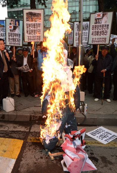 대한민국 어버이연합 등 보수단체 회원들이 서울 종로 주한 일본대사관 앞에서 일본 국회의원들의 야스쿠니 신사 참배를 규탄하는 내용의 집회를 가지며 아베신조 일본 총리의 형상을 불로 태우고 있다. 사진 어버이연합 홈페이지