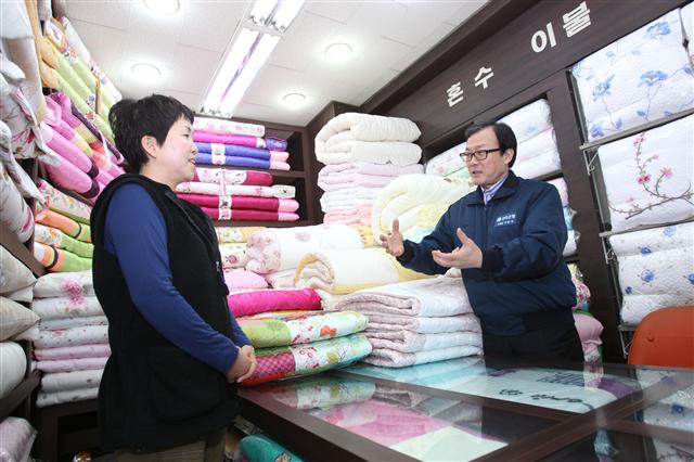 이순우(오른쪽) 우리금융회장 겸 우리은행장이 지난 2월 서울 종로구 광장시장 내 침구가게를 방문해 미소금융 상담을 하고 있다. 우리은행 제공
