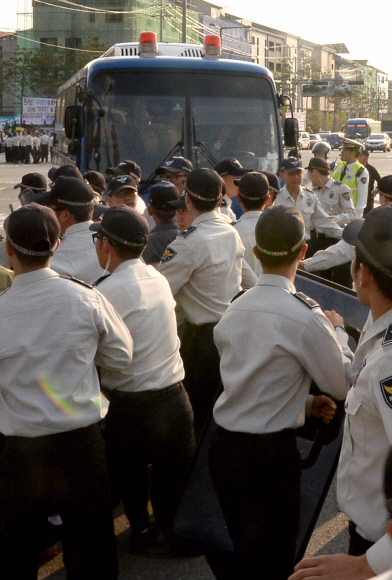 이석기 통합진보당 의원 등 4명에 대한 재판일인 14일 오후 경기도 수원시 수원지방법원에서 보수단체 회원들이 이석기 의원이 탄 호송차량을 막아서자 경찰이 이를 제지하고 있다. 박지환 popocar@seoul.co.kr