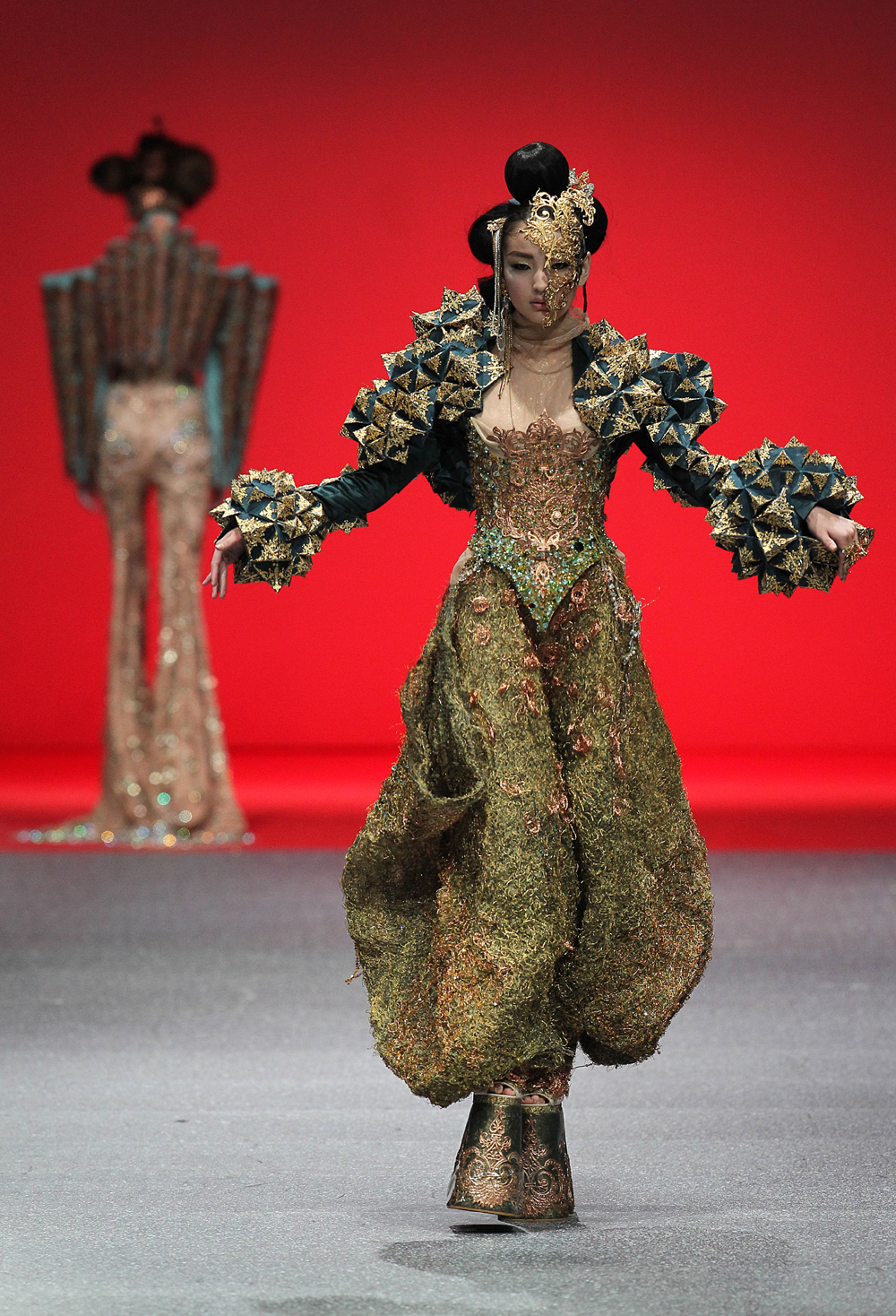 16일 싱가포르에서 열린 2013 아시아 패션 위크에서 중국의 패션 디자이너 ‘구오 페이’ 의 의상을 입은 모델이 포즈를 취하고 있다. AP/뉴시스 사진 제공