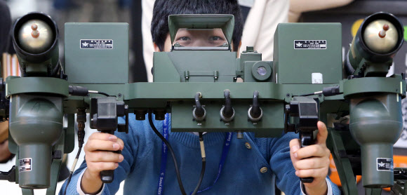 28일 경기도 고양시 킨텍스에서 열린 서울 국제 항공우주 및 방위산업 전시회(서울ADEX) 2013 프레스 설명회에서 참석자들이 신궁 다연발 발사대를 살펴보고 있다. 연합뉴스