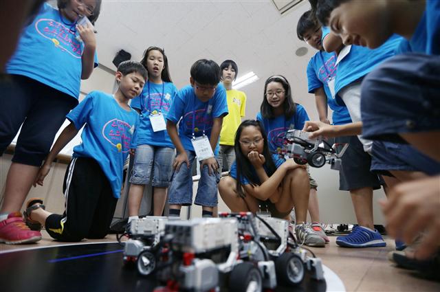 지난 7월 경희대 국제캠퍼스에서 열린 ‘소프트웨어 캠프’에 참가한 학생들이 직접 프로그래밍한 소프트웨어로 로봇을 작동시키고 있다.  삼성전자 제공