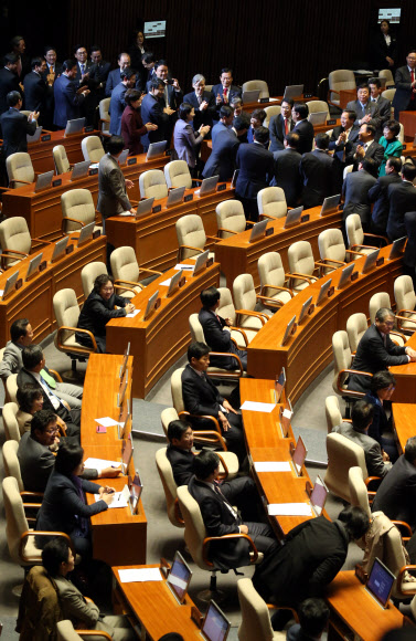 박근혜 대통령이 18일 오전 국회에서 열린 ’2014년도 예산안 시정연설’을 마치고 퇴장하자 여당 의원들은 자리에서 일어서 환송하는 한편 야당 의원들은 자리에 앉아 지켜보거나 외면하고 있다. 연합뉴스