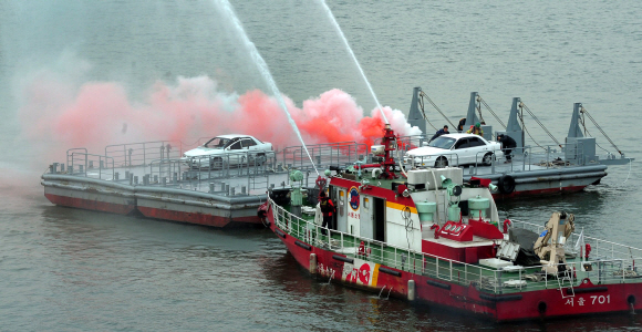 22일 오전 여의도 한강에서 열린 겨울철 수난사고 대비 유관기관 합동 구조훈련에서 서울시 소방재난본부 소속 119특수구조단 대원들이 마포대교 상판이 붕괴되면서 화재가 난 상황을 가정해 화재를 진압하는 훈련을 하고 있다. 박지환 popocar@seoul.co.kr