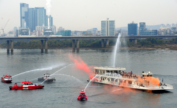 22일 오전 여의도 한강에서 열린 겨울철 수난사고 대비 유관기관 합동 구조훈련에서 서울시 소방재난본부 소속 119특수구조단 대원들이 마포대교 상판이 붕괴되면서 다리 밑을 통과하던 유람선에서 화재가 난 상황을 가정해 화재를 진압하는 훈련을 하고 있다. 박지환 popocar@seoul.co.kr
