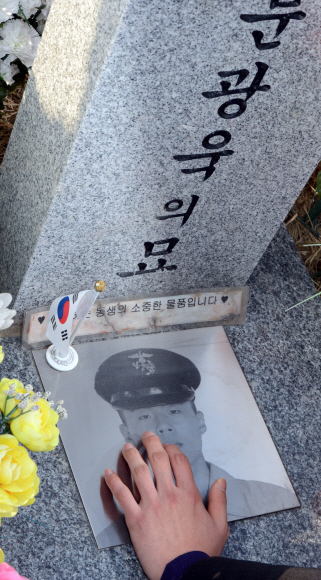 북한의 연평도 포격도발 3주기를 하루 앞둔 22일 오후 대전국립현충원에서 열린 추모식에서 故 문광욱 일병의 형이 사진을 어루만지고 있다. 도준석 pado@seoul.co.kr