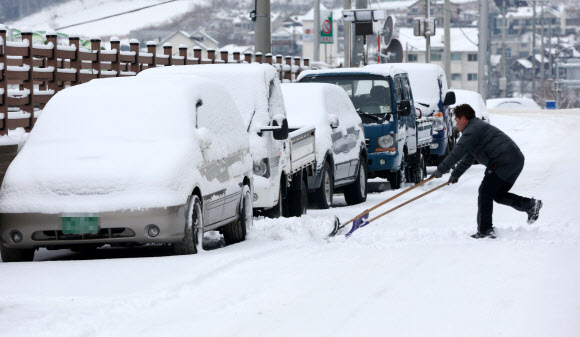 27일 대설특보와 함께 많은 눈이 내린 강원 평창군 대관령 시내에서 주민들이 인도에 쌓인 눈을 치우고 있다.  연합뉴스