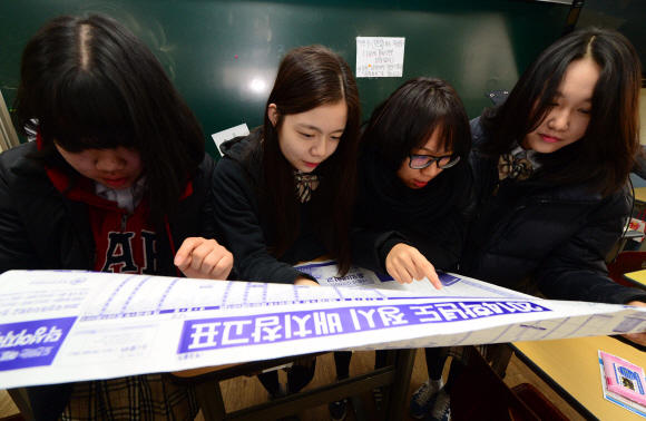 27일 서울 배화여고에서 3학년 학생들이 수능성적표를 받고 배치표를 살펴보고 있다.  정연호 기자 tpgod@seoul.co.kr