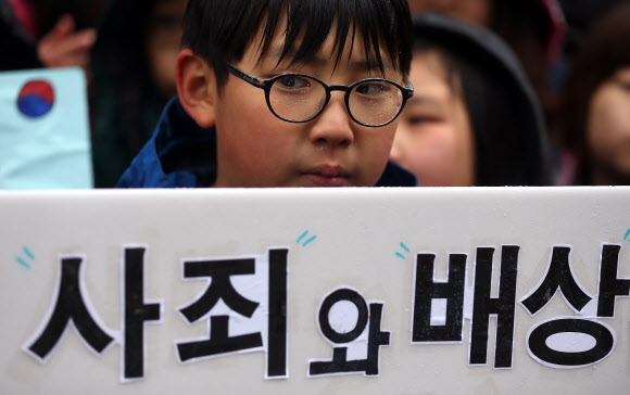 27일 오후 서울 종로구 주한일본대사관 앞에서 열린 ‘일본군 위안부 문제 해결을 위한 정기 수요시위’에 참가한 어린이들이 손피켓을 들고 있다.  연합뉴스