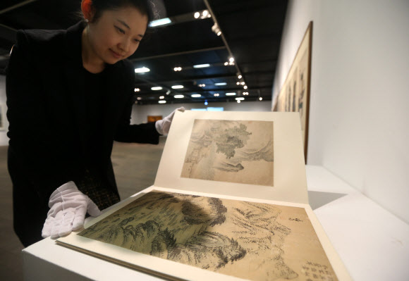 검찰이 전두환 전 대통령의 미납 추징금 환수를 위해 압류한 미술품 중 일부가 29일 언론에 공개됐다. 이날 오후 서울 평창동 서울옥션 본사에서 한 관계자가 겸재 정선의 작품이 실려 있는 화첩을 살펴보고 있다. 연합뉴스