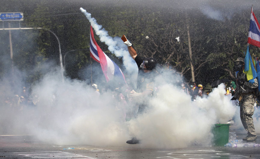 1일(현지시간) 방콕 반정부 시위대는 주요 정부 청사 주변에 집결해 총리 청사와 국립경찰본부 진입을 시도하자 태국 경찰은 시위대를 진압하려 최루탄을 던지고 있다. AP/뉴시스