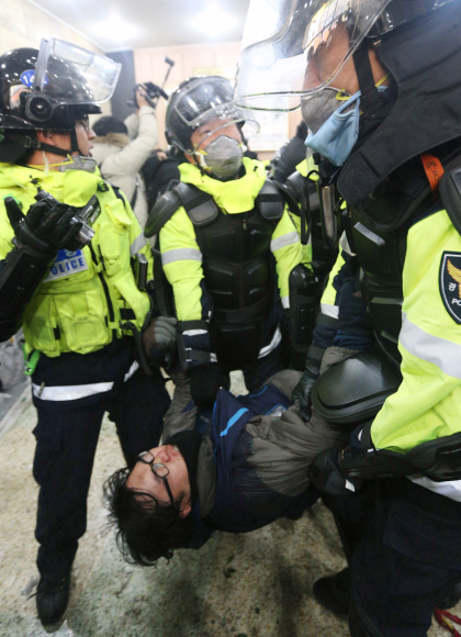 철도노조 지도부에 대한 체포영장 강제 집행이 시작된 가운데 경찰들이 22일 서울 중구 정동 민주노총 본부 1층에서 진입을 막아서는 노조 조합원을 강제로 끌어내고 있다. 