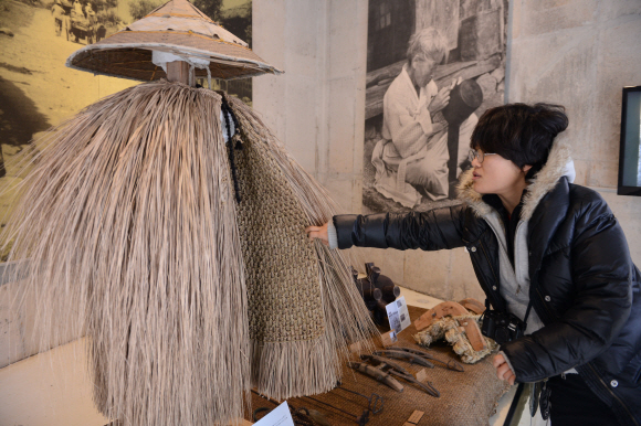 가시리마을 주민이 31일 조랑말박물관에 전시된 제주 전통 비옷인 ‘도롱이’를 만져 보고 있다. 도준석 기자 pado@seoul.co.kr