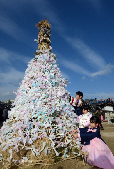 알록달록 달집에 새해소원 빌어요  새해 첫날 서울 중구 퇴계로 34길 28 남산골 한옥마을에서 어린이들이 달집에 소원첩을 달고 있다. 달집은 생소나무 가지 등을 쌓은 나무 무더기로 음력 정월 대보름날 달맞이할 때 불을 지른다.<br><br>도준석 기자 pado@seoul.co.kr