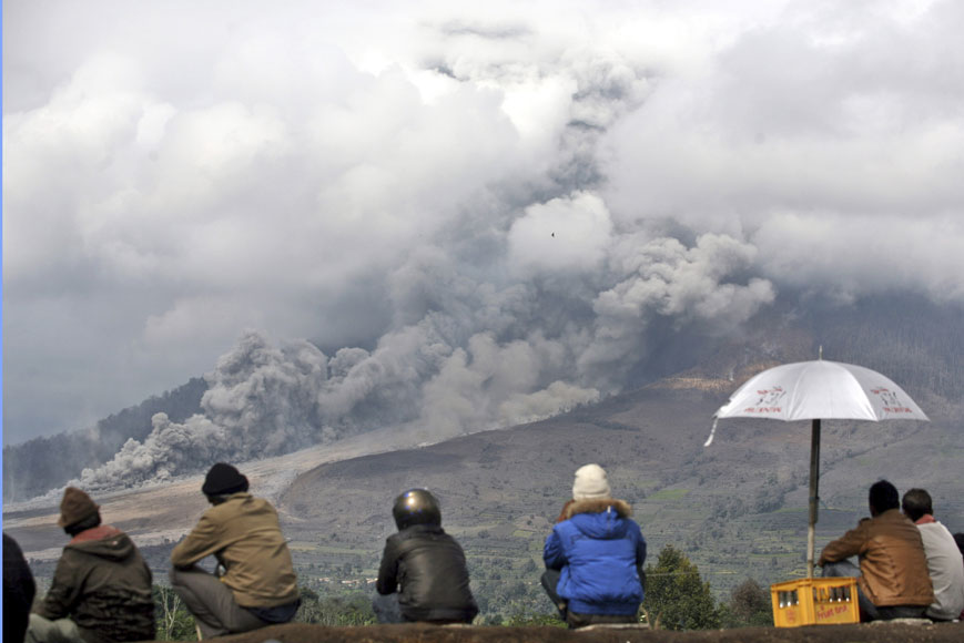 10일(현지시간)시나붕 화산이 폭발하면서 온통 진흙과 재로 뒤덮힌 인도네시아 수마트라 북부 타라키야트 마을을 주민들이 지켜보고 있다. AP/뉴시스