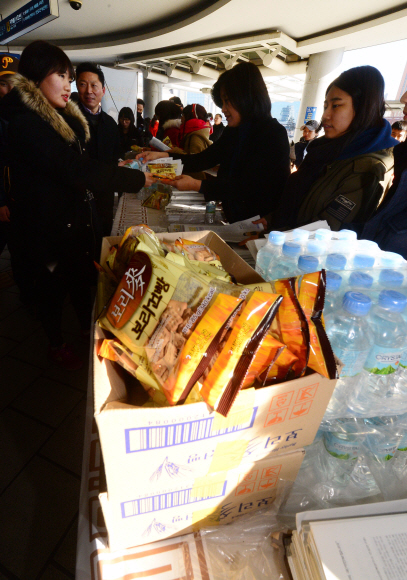 29일 서울역에서 시민단체 블루유니온 소속 회원들이 ’나라사랑 함께 표현해요’ 캠페인에서 귀성객들에게 생수와 건빵을 전달하고 있다. 정연호 기자 tpgod@seoul.co.kr