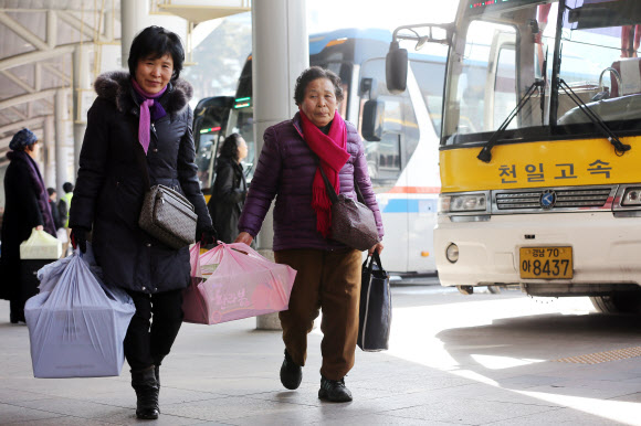 설 연휴를 하루 앞두고 본격적인 귀성이 시작된 29일 서울 강남고속버스터미널에서 역귀성객들이 양손에 짐을 들고 이동하고 있다. 연합뉴스