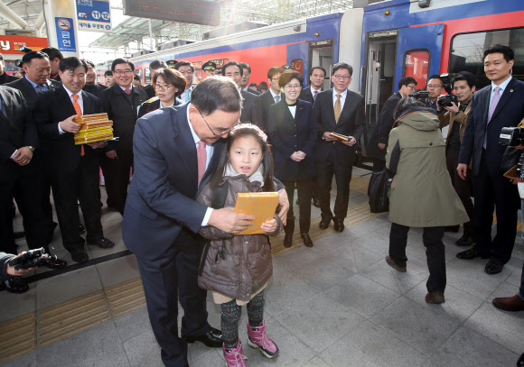 정홍원 국무총리가 본격적인 귀성이 시작된 29일 오후 서울역을 찾아 부산행 무궁화호에 오르는 한 어린이에게 학용품을 선물하고 있다.  연합뉴스