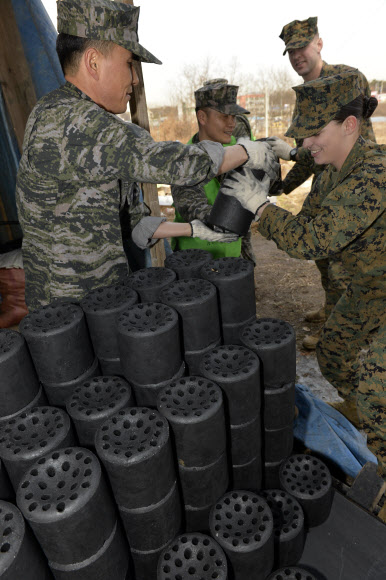 한·미 해병대원들이 29일 화성시 팔탄면 일대 홀로 사는 노인 및 저소득층 가정을 방문해 ’설맞이 사랑의 연탄배달’ 봉사활동을 하고 있다. 해병대사령부 제공