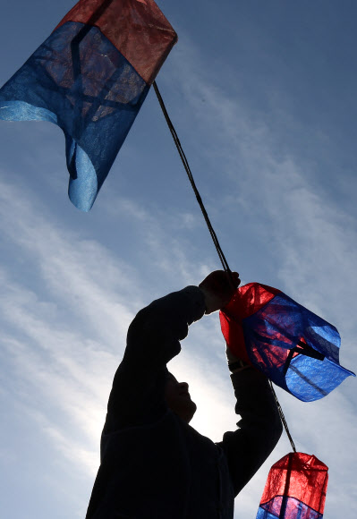 설 연휴를 하루 앞둔 29일 오전 서울 중구 남산골한옥마을에서 한 직원이 청사초롱 교체작업을 하고 있다. 연합뉴스