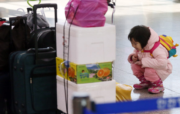 설연휴를 하루 앞둔 29일 오전 인천시 중구 인천연안여객터미널에서 한 어린이가 고향인 연평도로 향하는 여객선을 기다리며 짐을 점검하고 있다.  연합뉴스