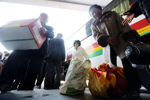 설 연휴를 하루 앞두고 본격적인 귀성이 시작된 29일 서울 강남고속버스터미널에서 역귀성객들이 짐을 들고 이동하고 있다.  연합뉴스