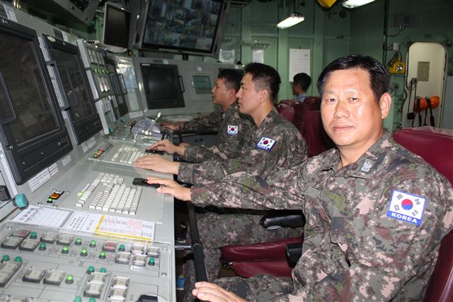 안승웅(오른쪽) 해군 원사가 29일 최영함 기관조종실에서 후배들과 모니터로 엔진 상태를 점검하고 있다.  청해부대 제공