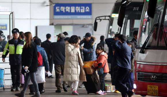 설 연휴 마지막날인 2일 오전 서울 서초구 반포동 고속버스터미널에서 고향을 방문하고 돌아온 시민들이 짐을 들고 버스에서 내리고 있다.  연합뉴스