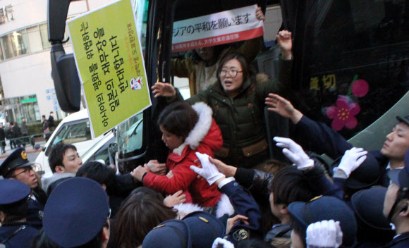 원정대의 한 여성이 일본의 재무장에 반대한다는 피켓을 내걸자 일본 경찰이 이를 쳐내 피켓이 허공에 떠 있다.  연합뉴스