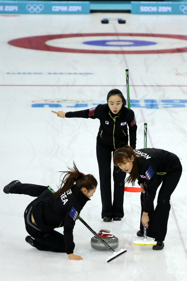 11일 오전(현지시간) 러시아 소치 해안클러스터 아이스큐브 컬링센터에서 열린 여자 컬링 예선 한국과 일본 경기에 앞서 이슬비가 브룸으로 얼음을 닦던 중 넘어지고 있다. 사진 왼쪽부터 이슬비, 김지선, 김은지. 연합뉴스