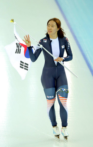 한국 스피드스케이팅의 이상화가 11일(현지시간) 러시아 소치 해안클러스터의 아들레르 아레나에서 열린 2014 소치 동계올림픽 스피드스케이팅 여자 500ｍ 경기에서 금메달을 차지, 올림픽 2연패를 달성한 뒤 태극기를 들고 환호하는 관중에게 손을 흔들고 있다. 연합뉴스