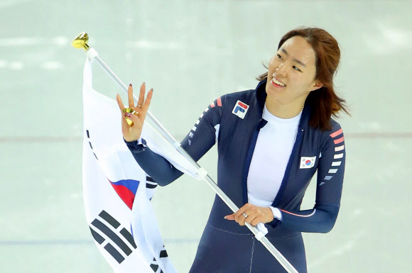한국 스피드스케이팅의 이상화가 11일(현지시간) 러시아 소치 해안클러스터의 아들레르 아레나에서 열린 2014 소치 동계올림픽 스피드스케이팅 여자 500ｍ 경기에서 우승, 올림픽 2연패를 달성한 뒤 태극기를 들고 손을 흔들며 환호하는 관중에게 화답하고 있다. 연합뉴스