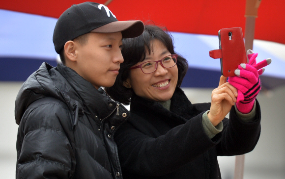 충남 논산시 육군훈련소에서 입소 장병이 지난 17일 배웅을 나온 어머니와 휴대전화로 사진을 찍고 있다.  논산 박지환 기자 popocar@seoul.co.kr