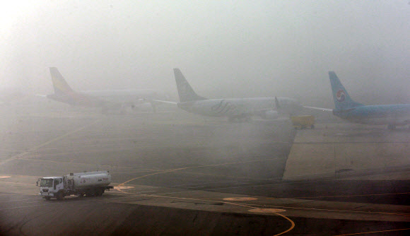 짙은 안개에 발 묶인 항공기들  25일 오전 짙은 안개와 중국발 미세먼지의 영향으로 김포공항에서 항공기 운항에 차질이 빚어지고 있다.<br>안개 낀 김포공항 활주로에 항공기들이 출발을 기다리고 있다. <br>연합뉴스