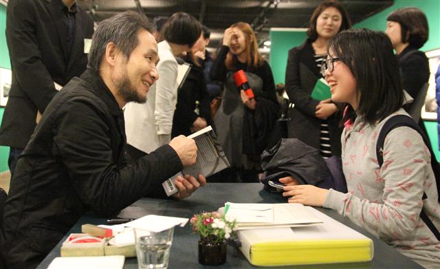 박노해(왼쪽) 시인이 서울 광화문 세종문화회관 지하 전시실에서 전시장을 찾은 관람객과 대화를 나누고 있다. 나눔문화 제공